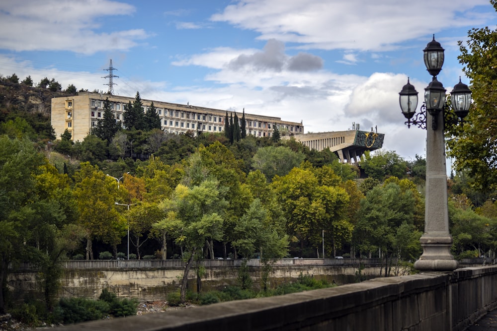 Edificios de hormigón blanco rodeados de árboles altos y verdes bajo cielos azules y blancos