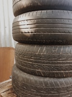 Used car tires stacked in a warehouse with natural light coming through