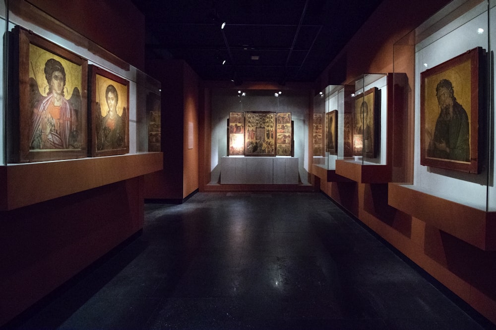 hallway with displayed paintings on wall in glass cases