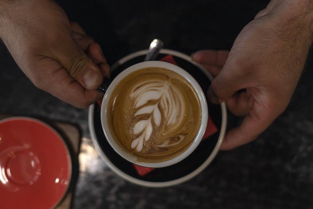 Person, die einen Becher Kaffee in der Hand hält