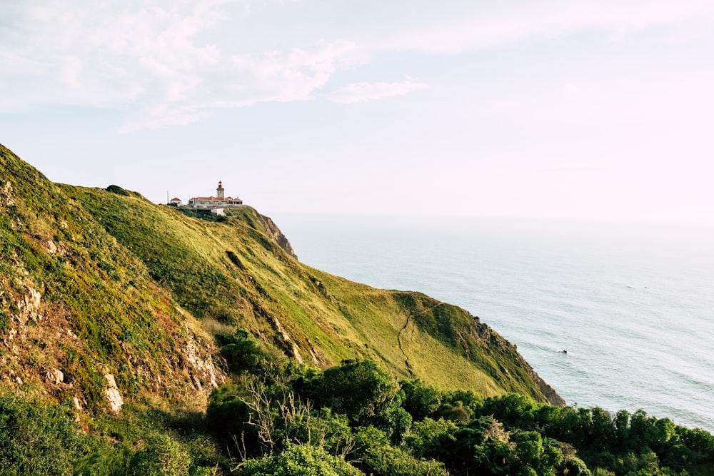 white and brown house on top of hill overlooking sea