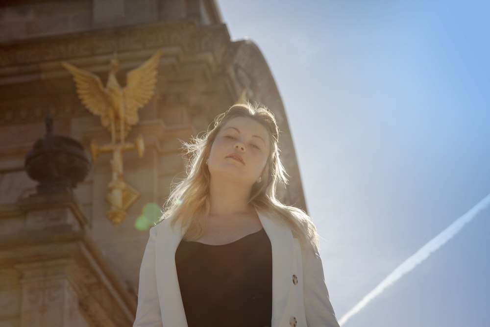 woman in white blazer standing by the monument