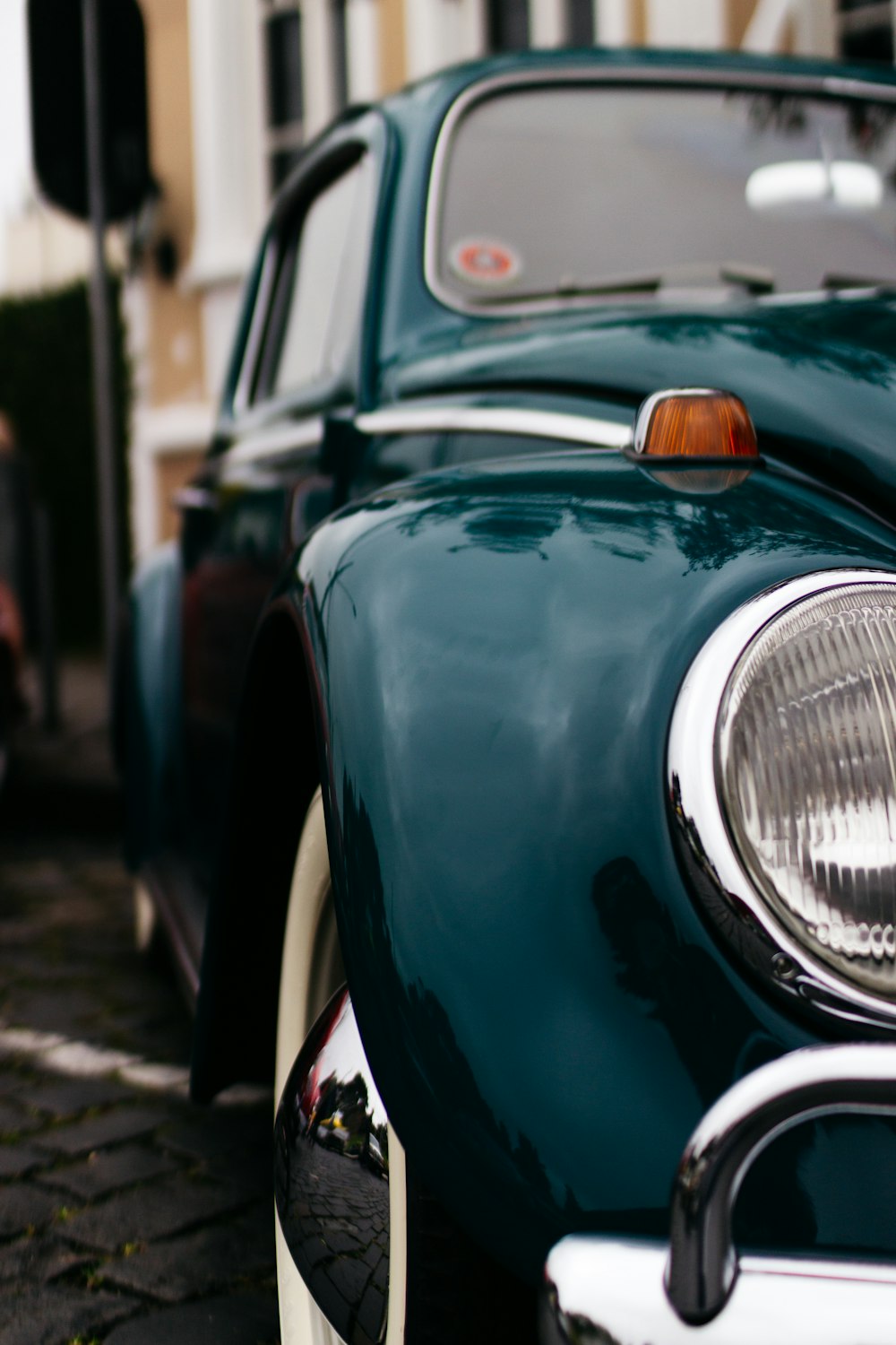 green classic Volkswagen Beetle parked at street