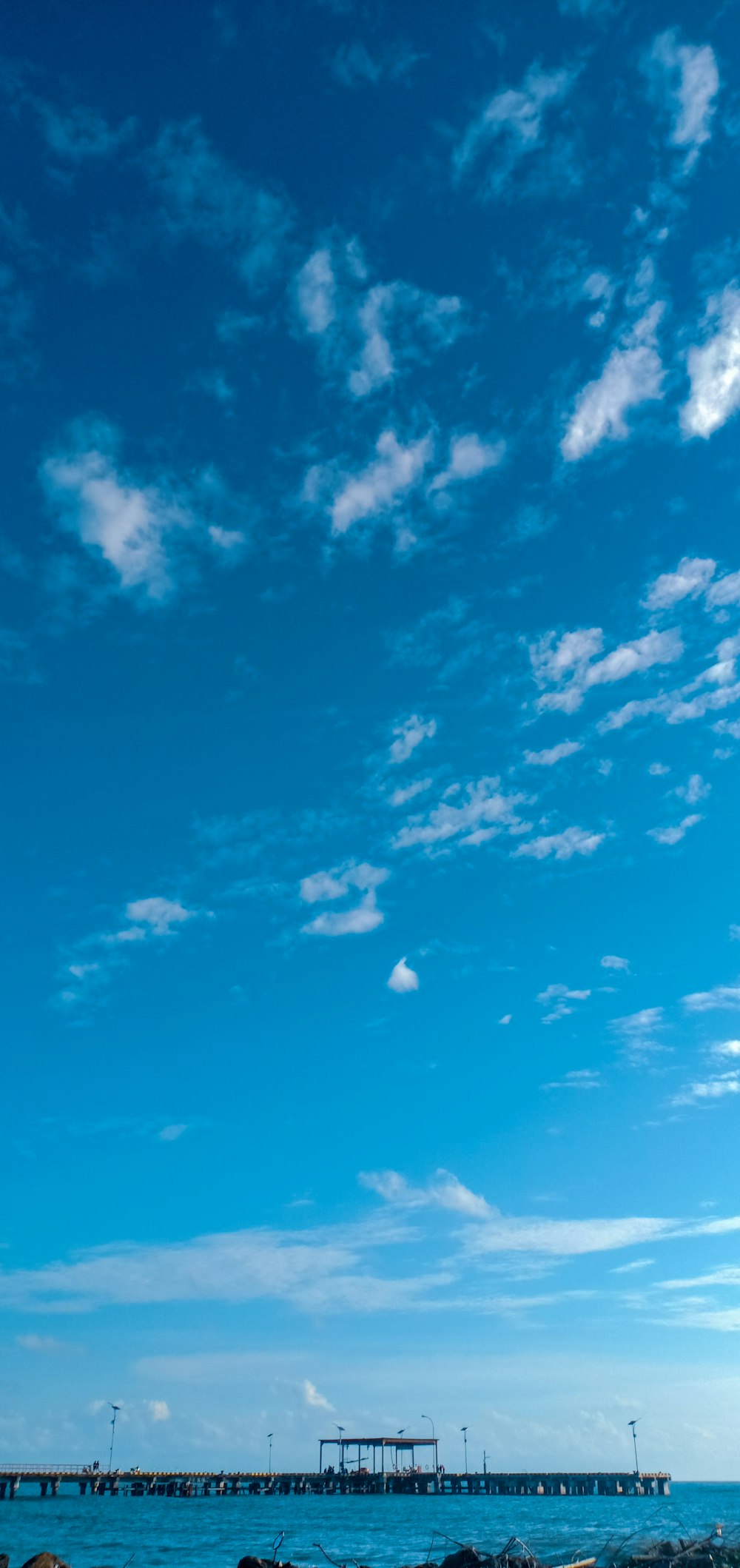 ciel nuageux blanc et bleu au-dessus de la jetée