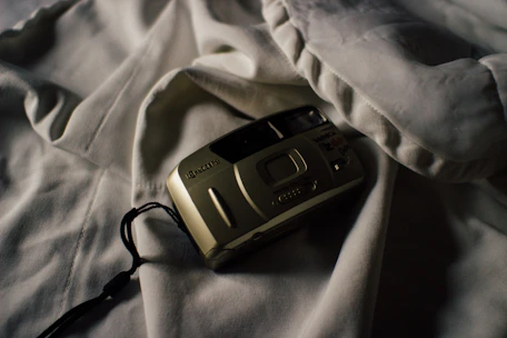 A moody black and white shot of a film camera on set, capturing an intimate moment.