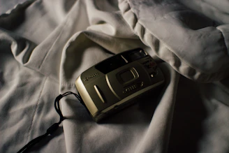 A moody, elegant shot of a vintage film camera casting shadows on a dark textured surface.