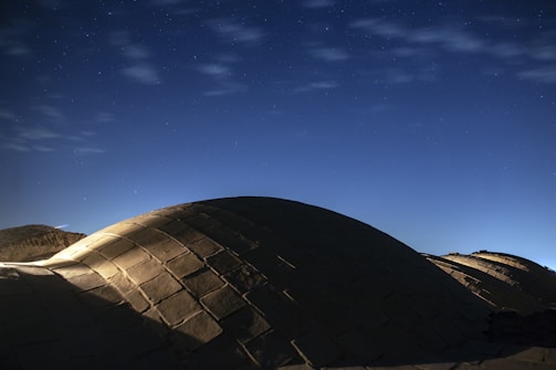 A panoramic view of the Mekao village with multiple illuminated domes under a starry sky.