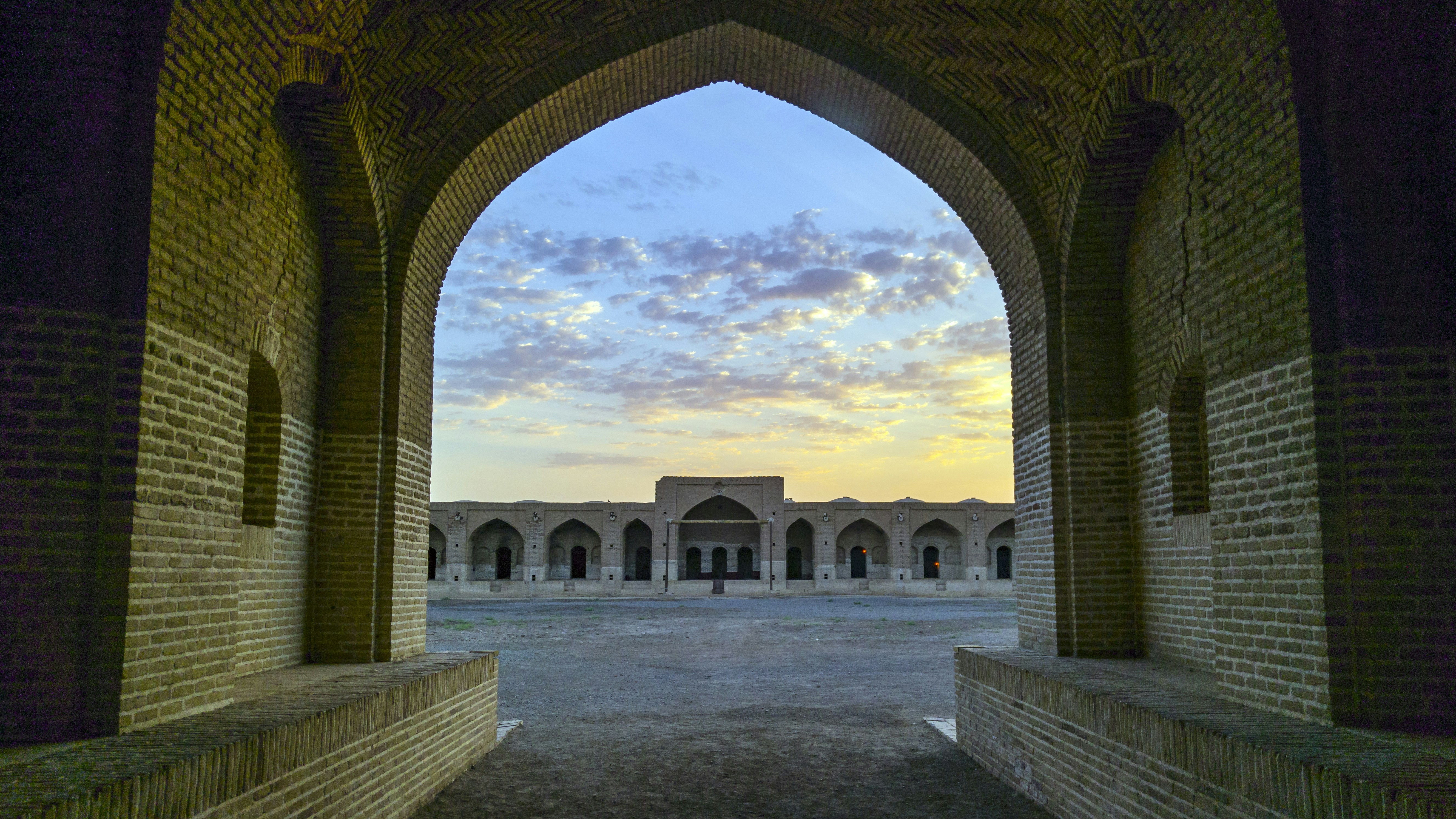 white concrete building showing pathway under blue and white skies