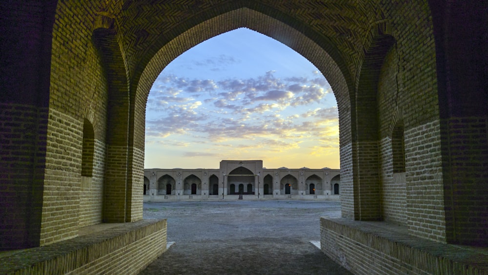 white concrete building showing pathway under blue and white skies