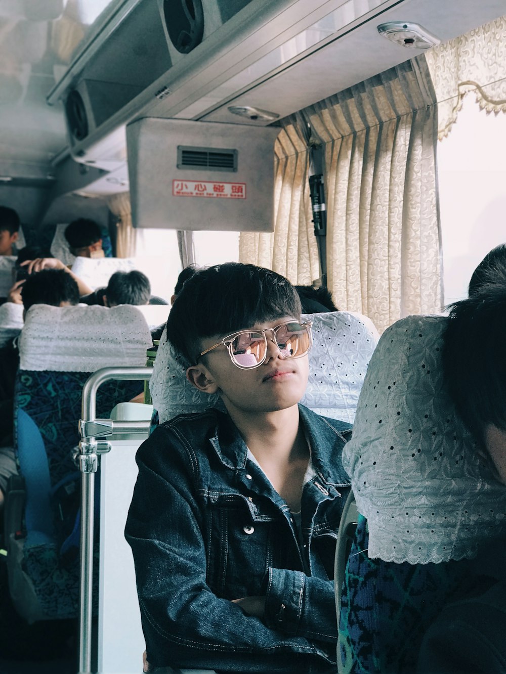 boy in blue denim jacket in bus seat