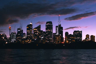 A dramatic aerial shot of Leicester city skyline at twilight with glowing lights and deep blue skies.