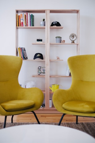 two yellow chairs near brown shelf