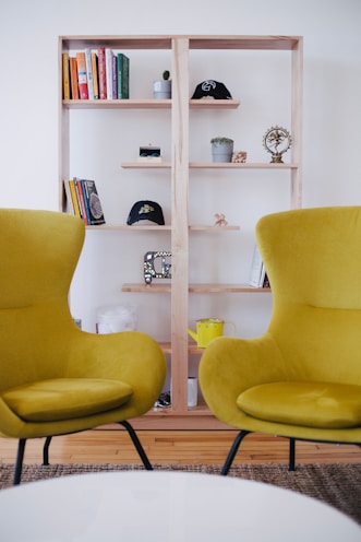 two yellow chairs near brown shelf