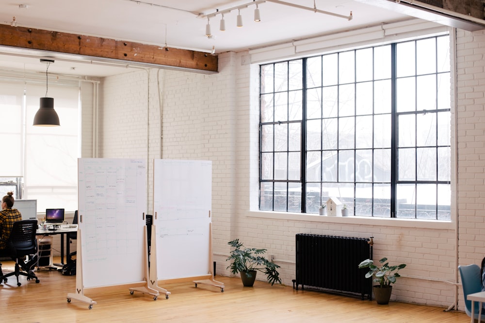 two white projector screens across room