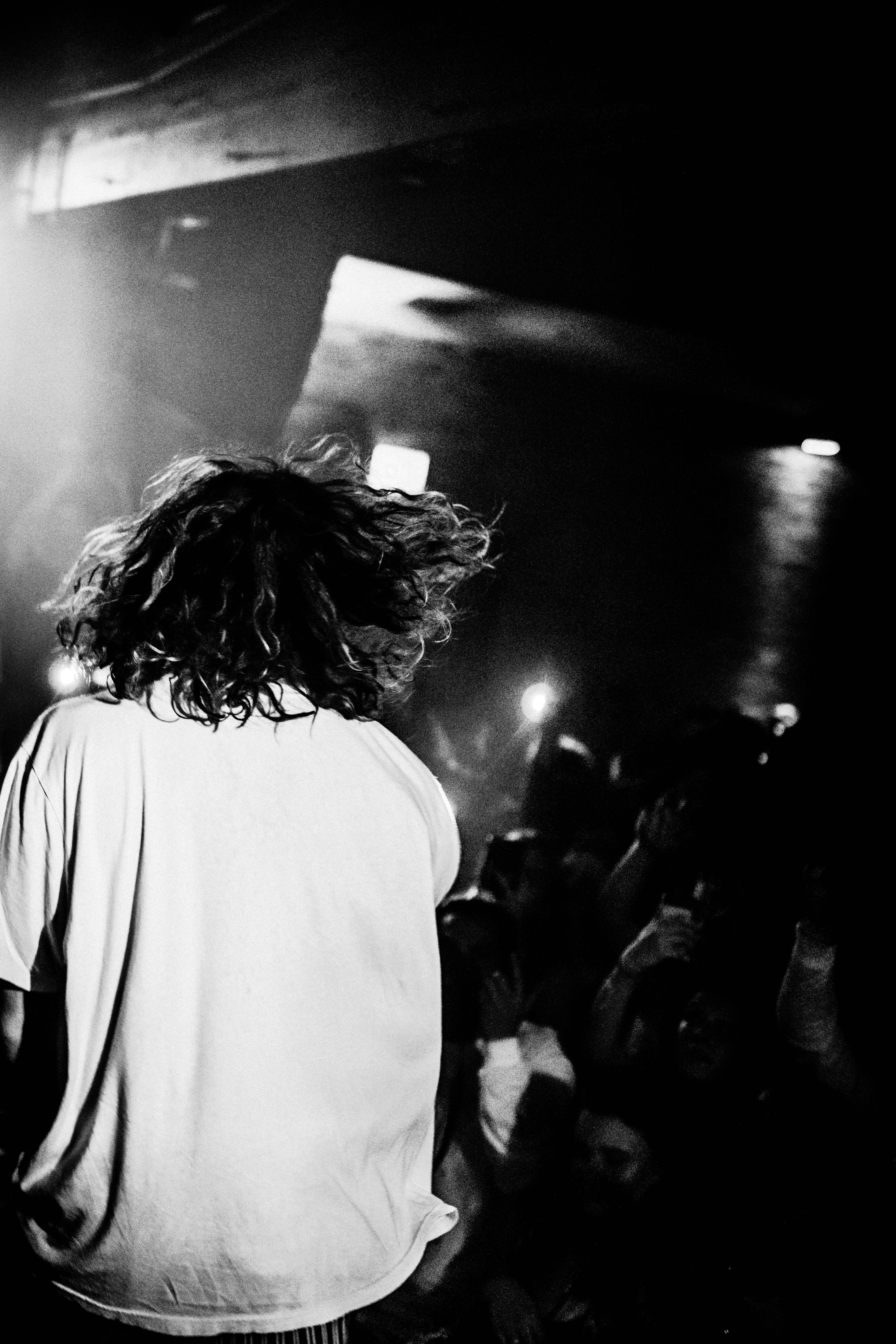 grayscale photo of man performing on stage