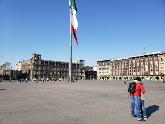 couple hugging near flagpole in Palacio de Bellas Artes Mexico