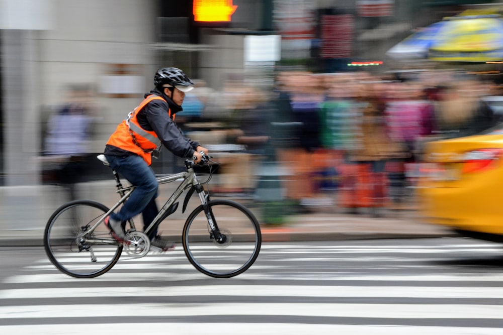 man riding bike near people and car