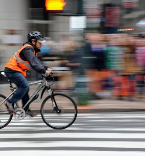 man riding bike near people and car