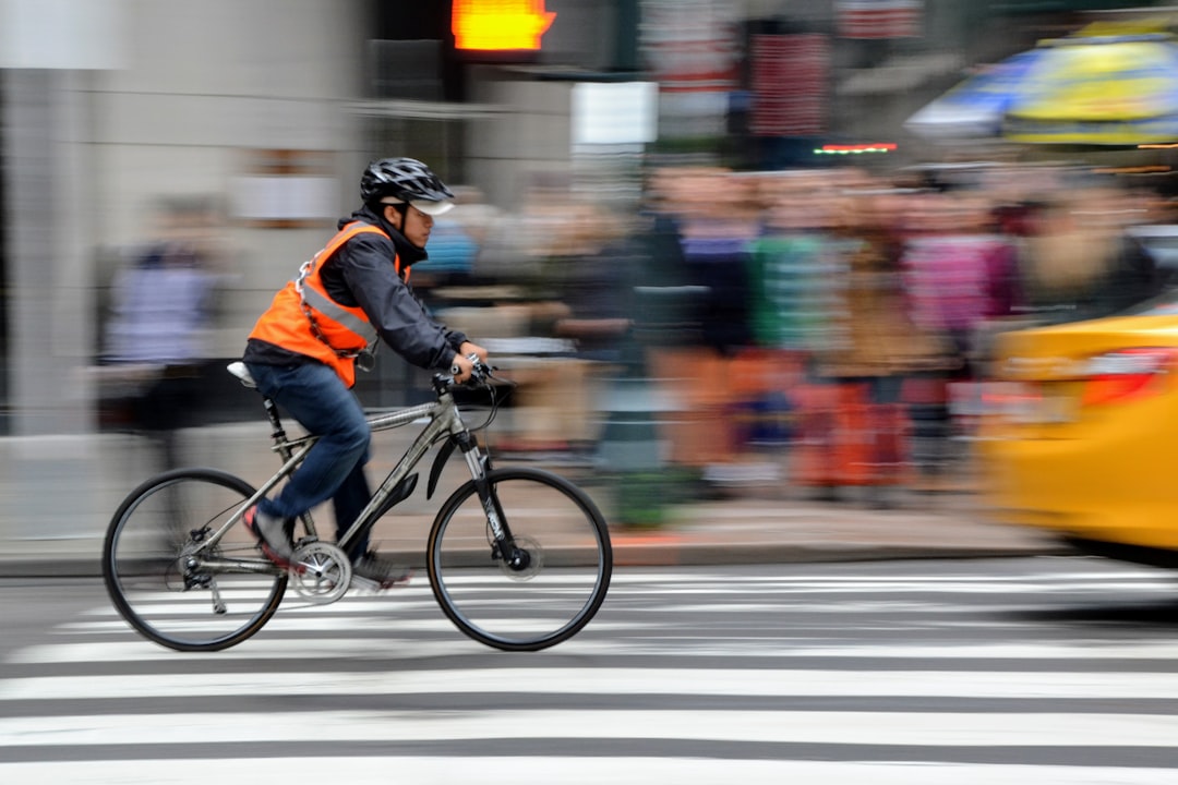 man riding bike near people and car, Man riding bicycle in New York street<p></figure>Hombre en bicicleta en calle de Nueva York