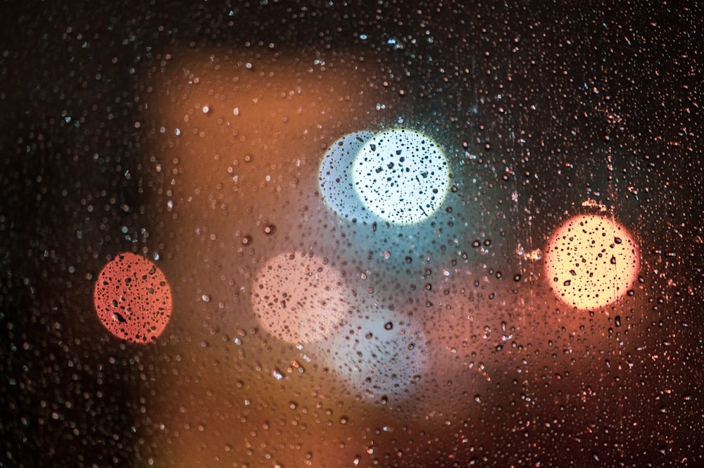 rain drops on a window with traffic lights in the background