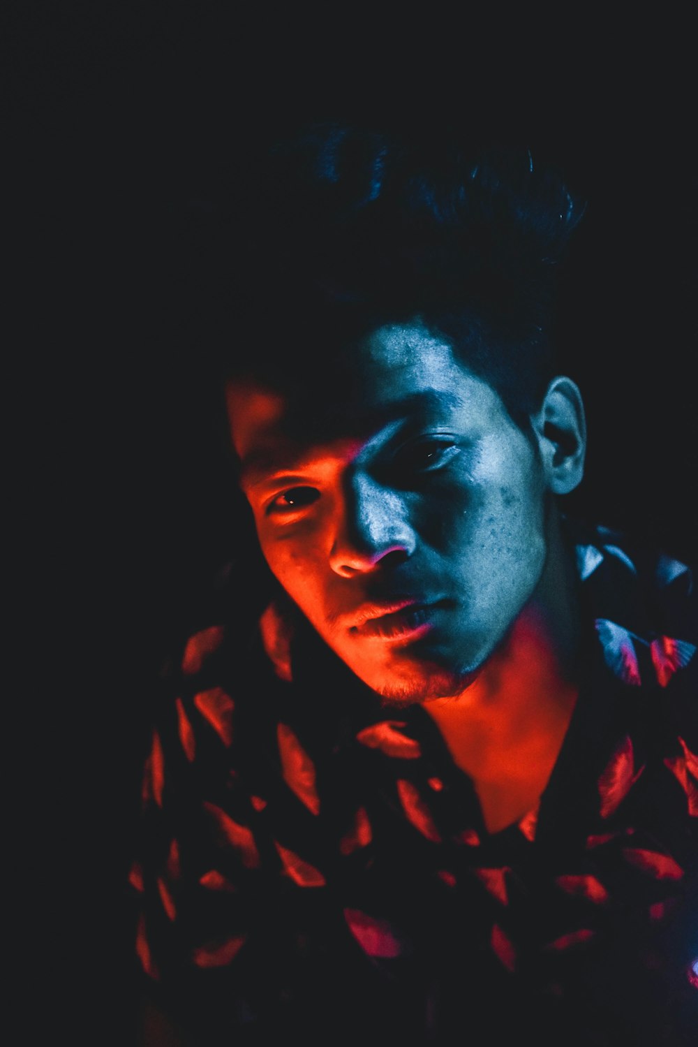 man in black and red shirt in dark room