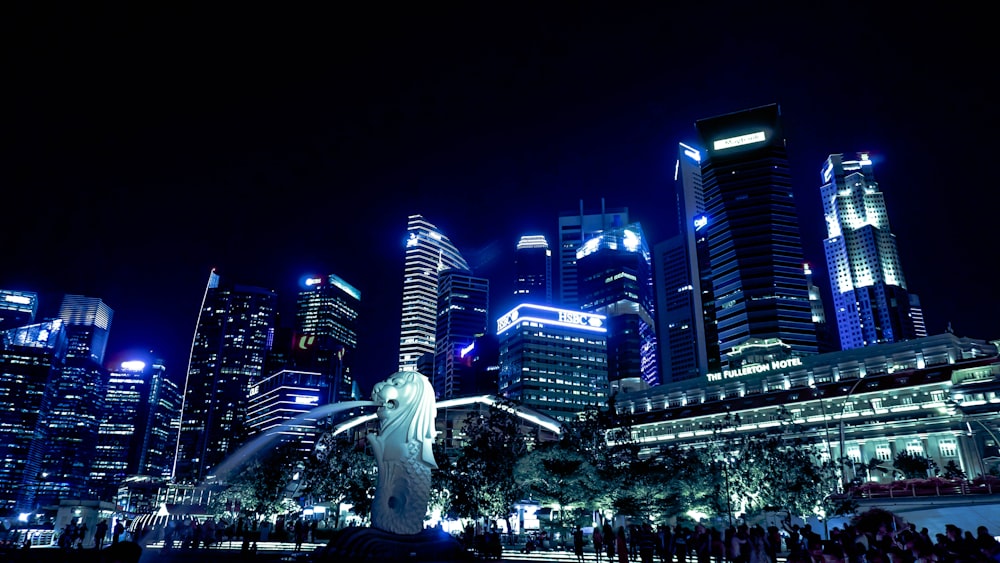 lighted Singapore skyline with view of the Merlion statue