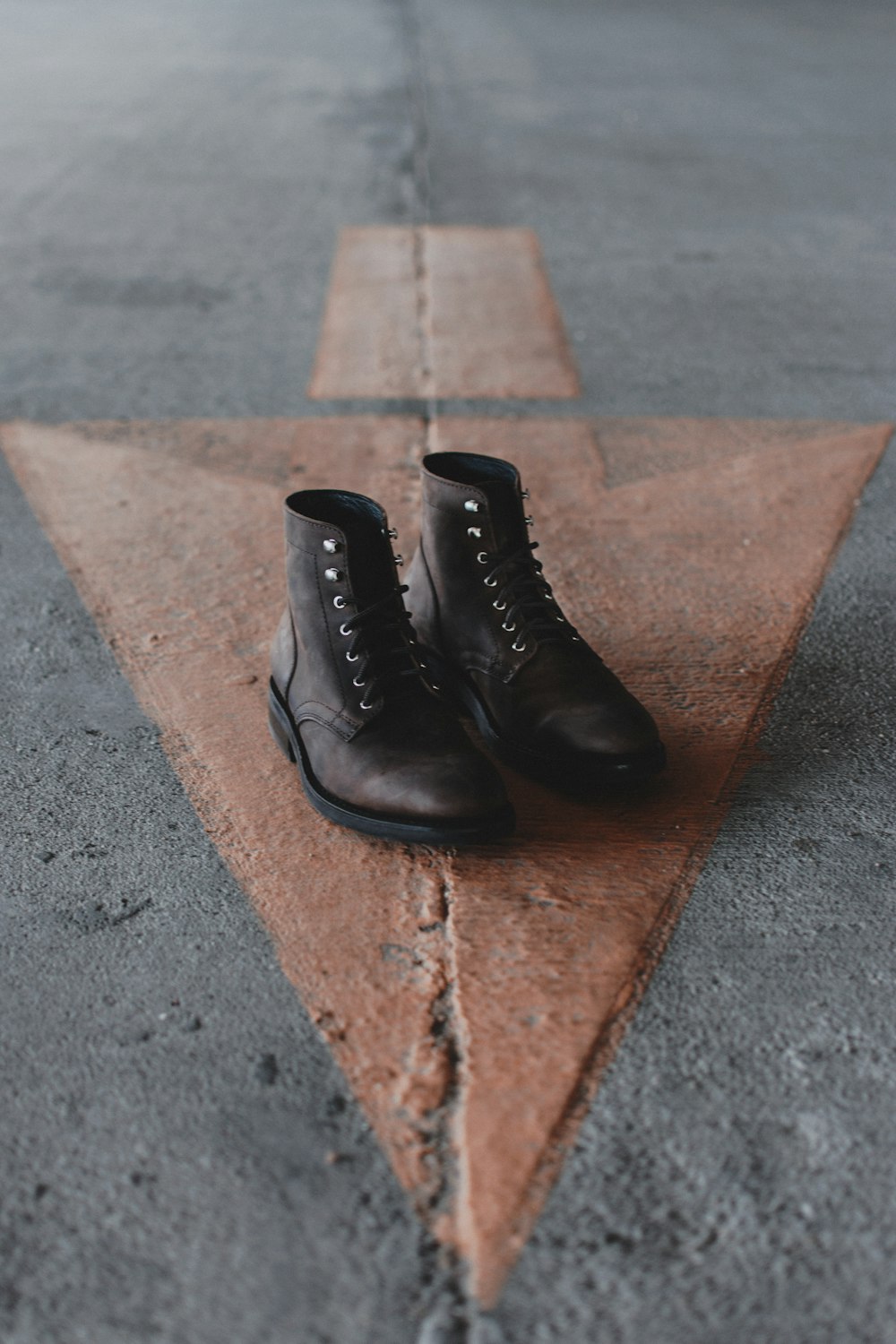 pair of brown leather boots on pavement