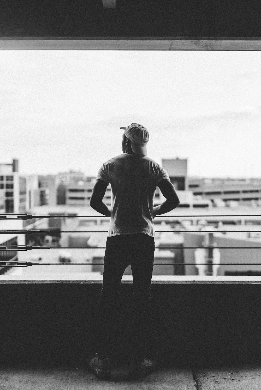 man standing beside handrail of a building