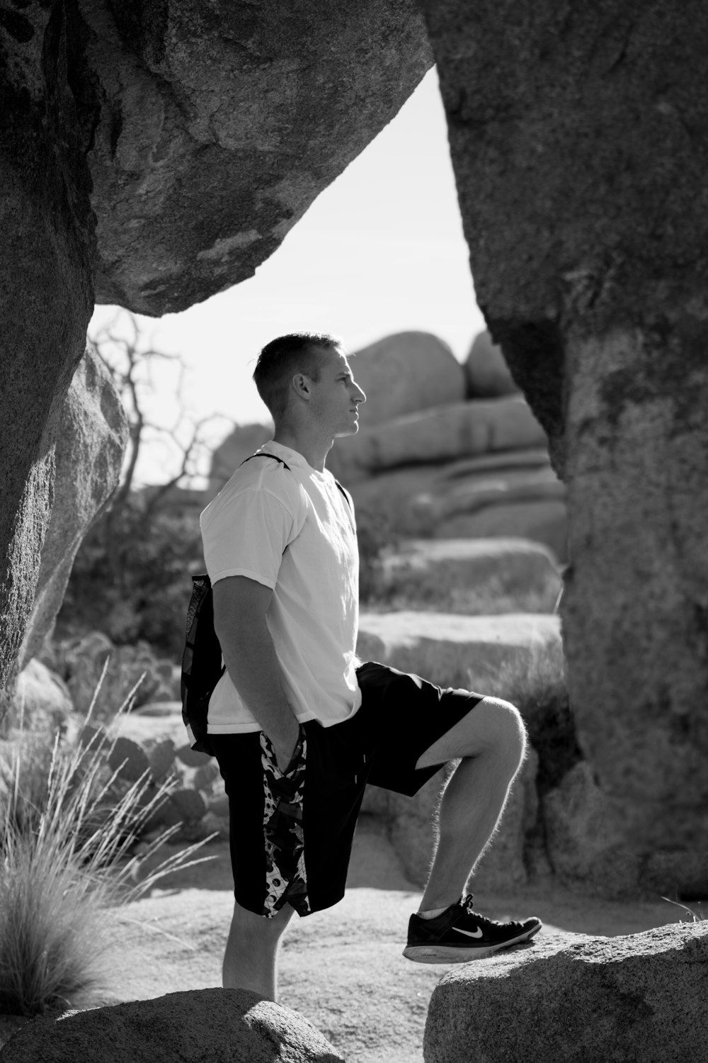 graysclae photography of man standing on rock