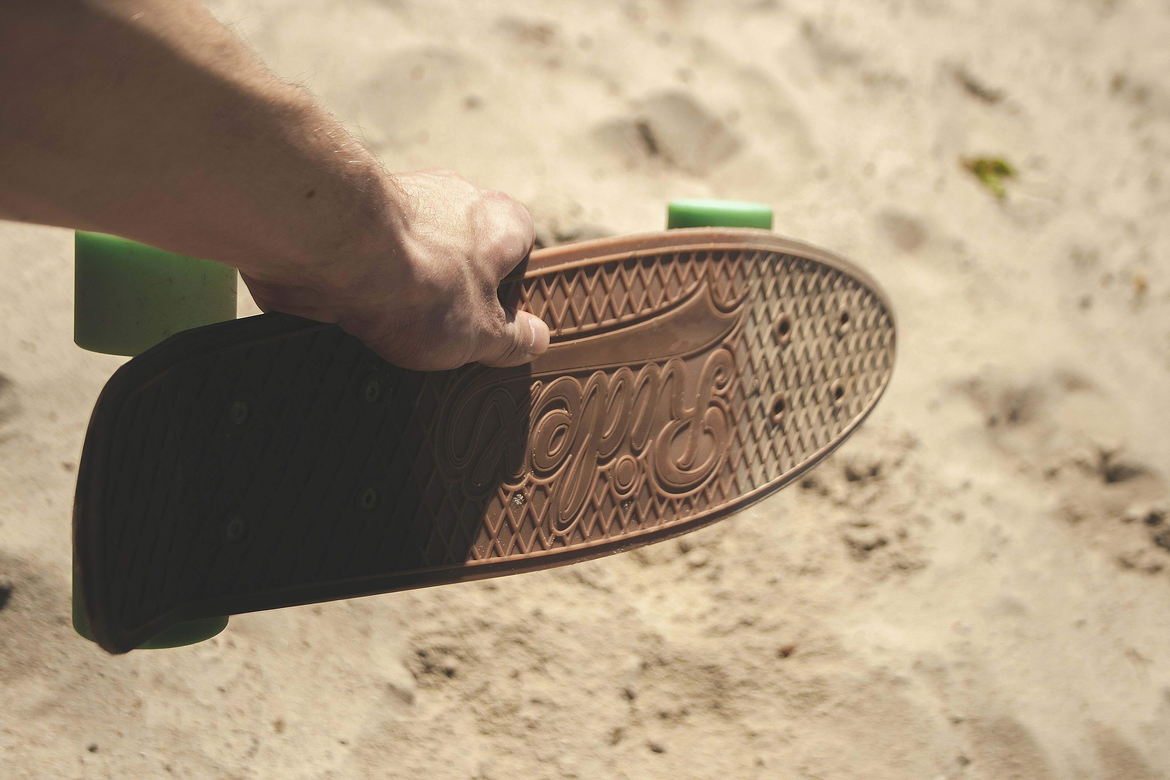 person holding brown penny board