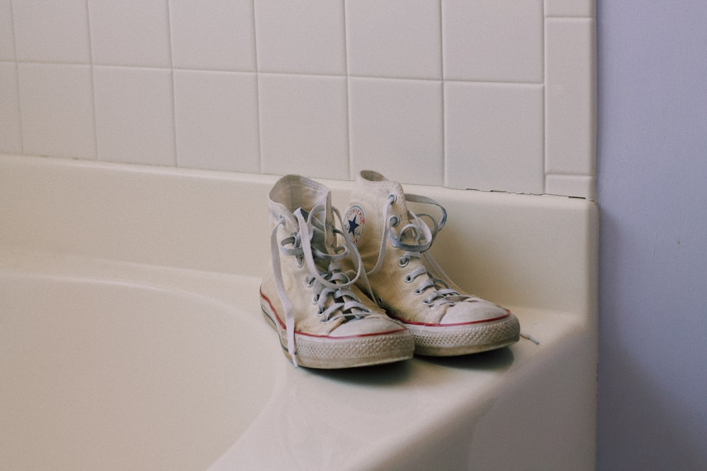 pair of white high-top shoes on sink