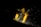 A person in a dark environment is engaged in welding, wearing protective clothing and a helmet. Bright sparks fly around, illuminating parts of the person and the workspace.