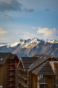 Cleaning team working on spotless alpine chalet windows with snowy mountains in the background.