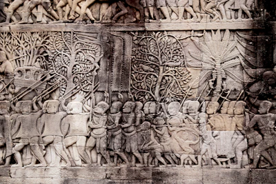 Bas-relief carving of a Khmer army procession on a temple gallery wall (via Unsplash)