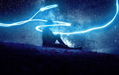 A mystical scene with a person meditating under a starry sky.