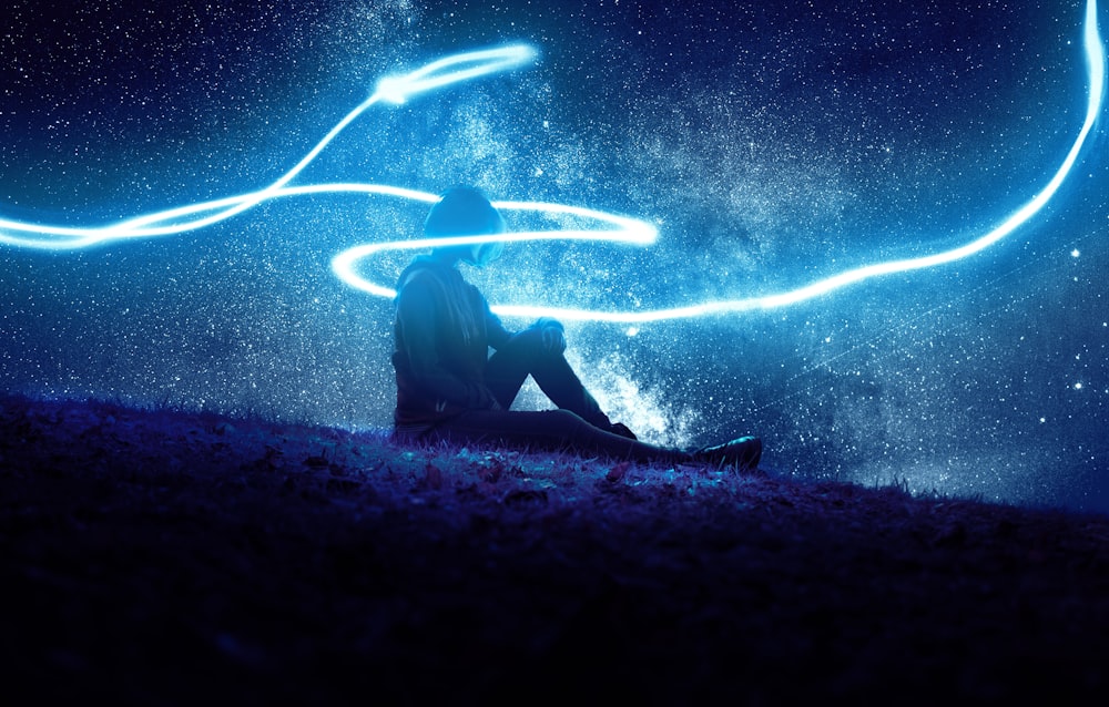 person sitting under blue LED lights