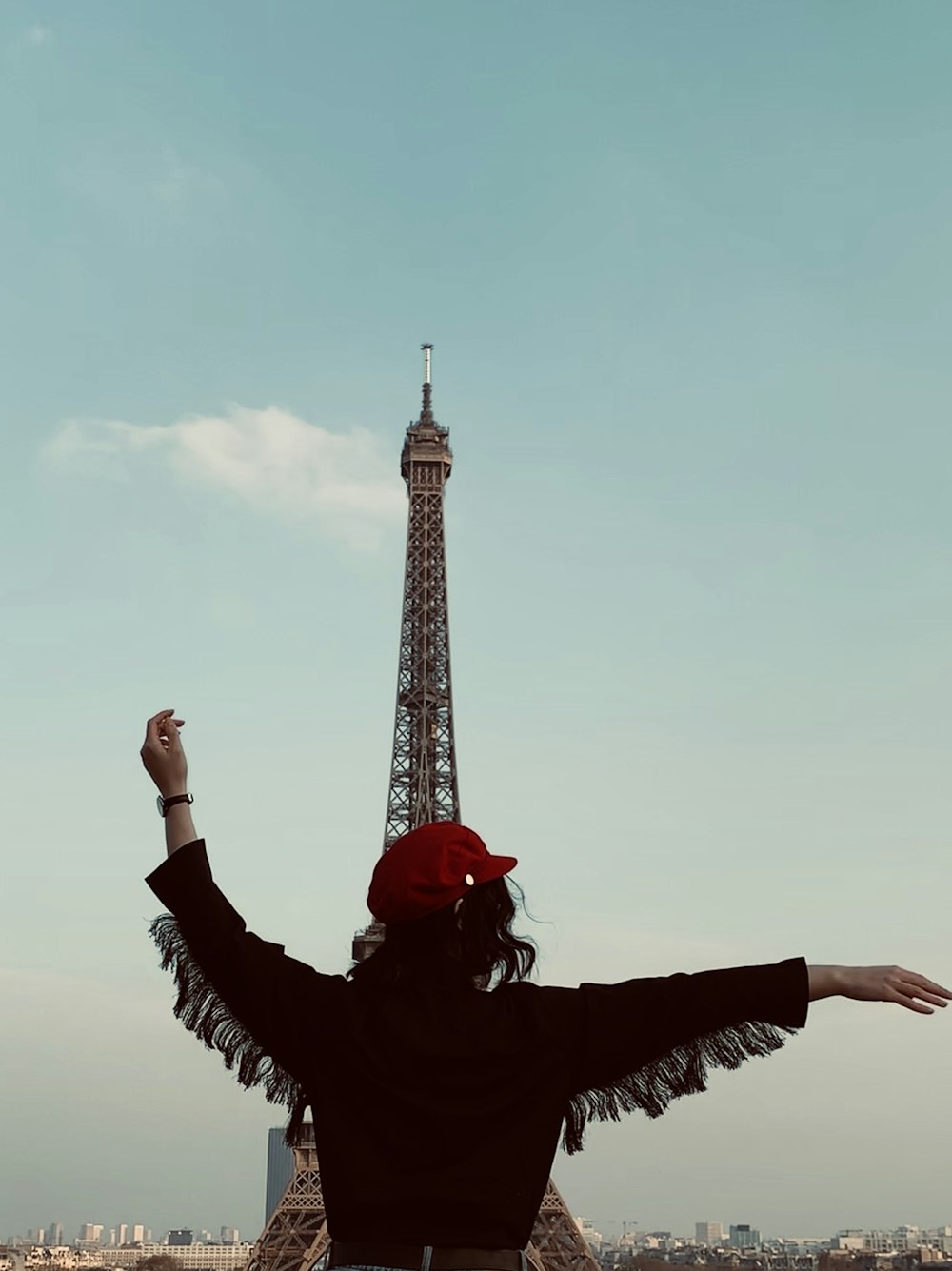 donna che indossa una camicia nera a maniche lunghe vicino alla Torre Eiffel