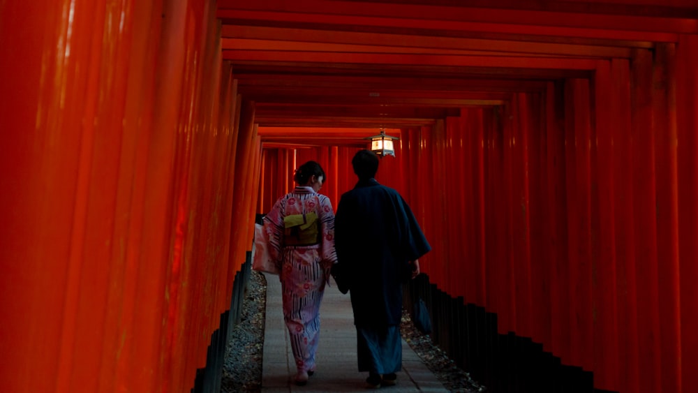 two person wearing traditional dresses walking on hallway