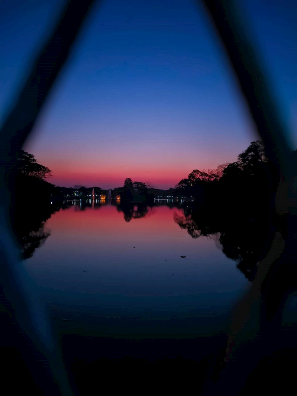 silhouette of buildings and trees near lake