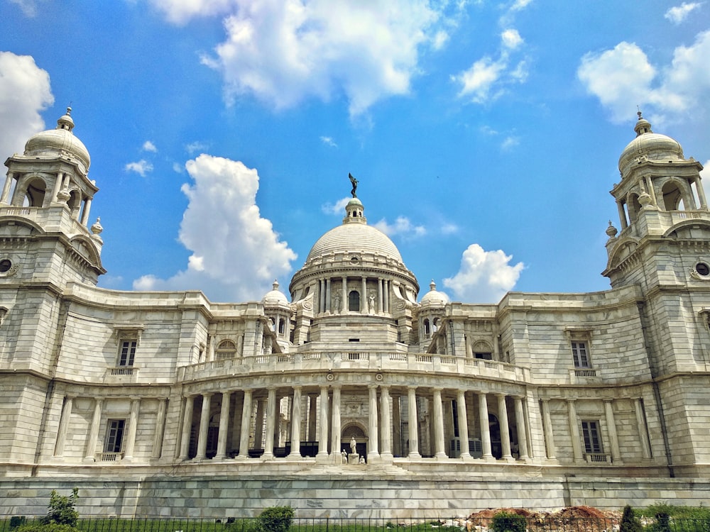 white dome building under blue and white skies