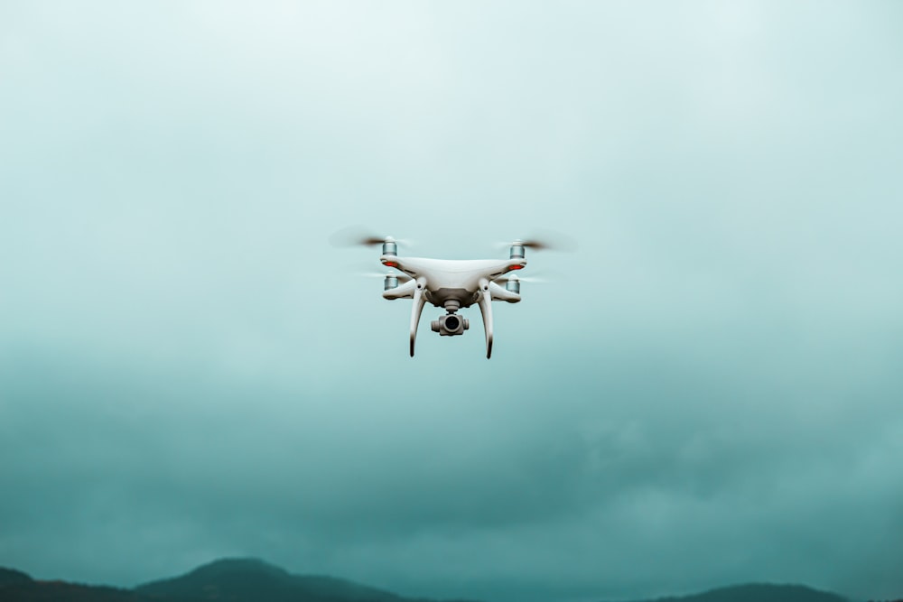 white quadcopter drone in flight
