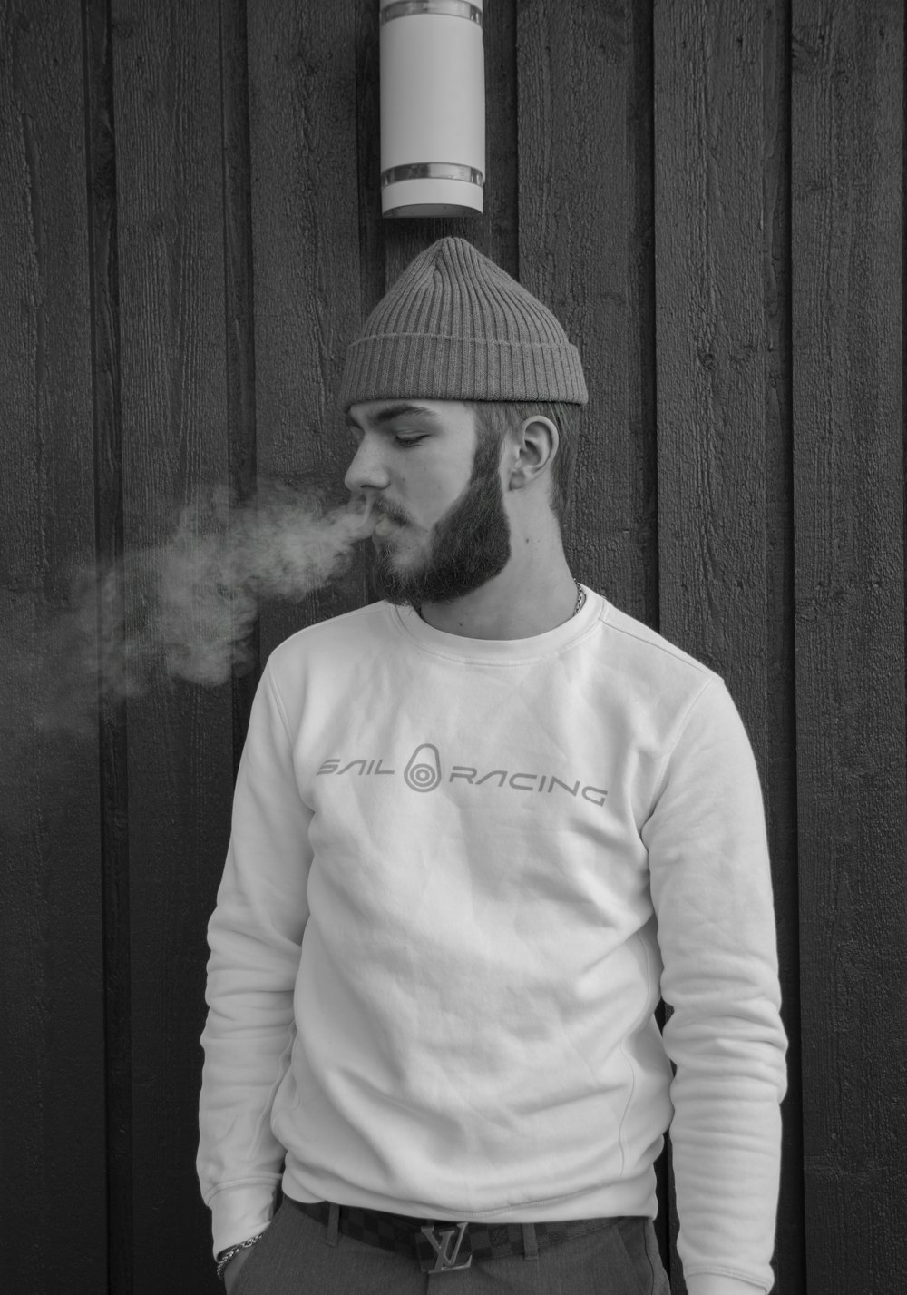 grayscale photo of man blowing smoke