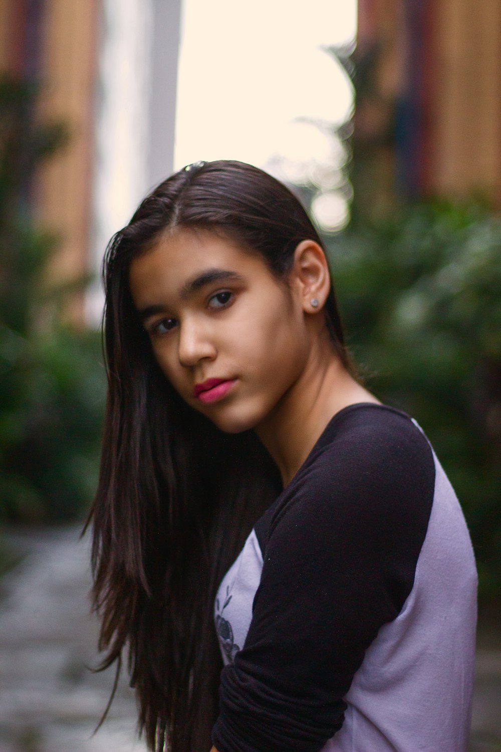 woman in black and white sweat shirt looking over left shoulder