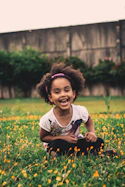 girl's white and black crew-neck cap-sleeved shirt sitting on grass