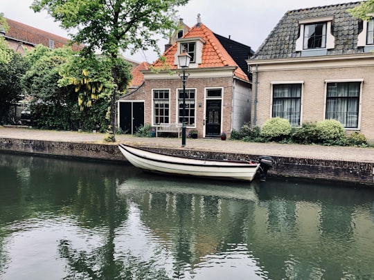 white motorboat moored in riverside in front of houses in Hoorn Netherlands