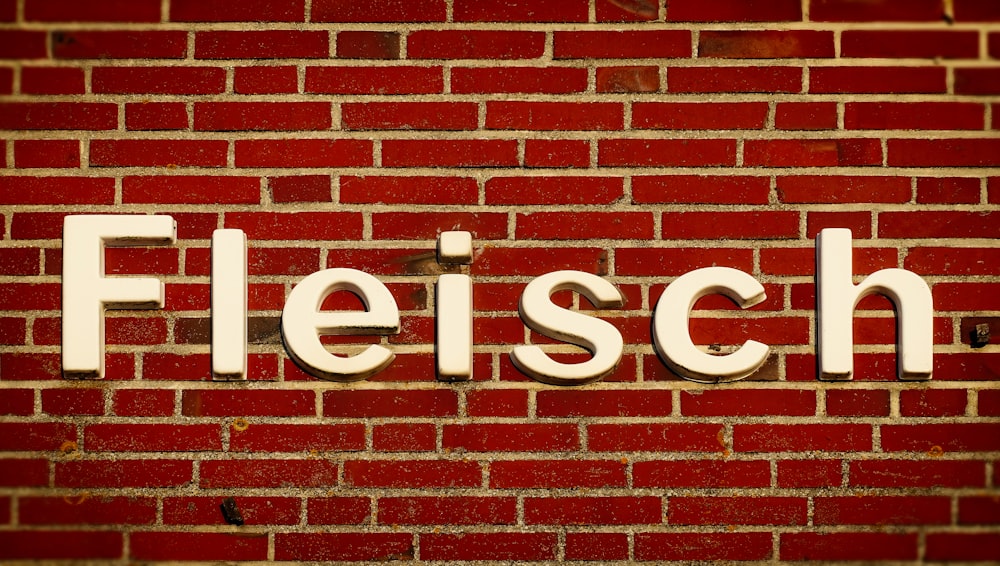 letrero blanco de Fleisch en pared de ladrillo rojo