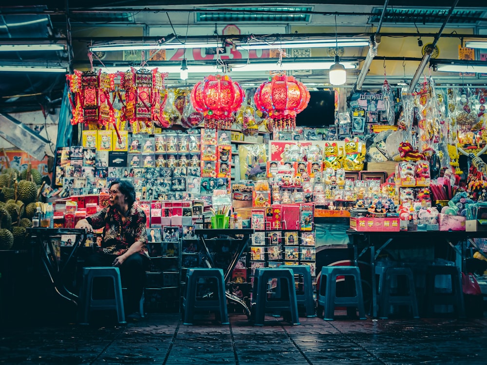 woman sitting in front of stall full with products on display