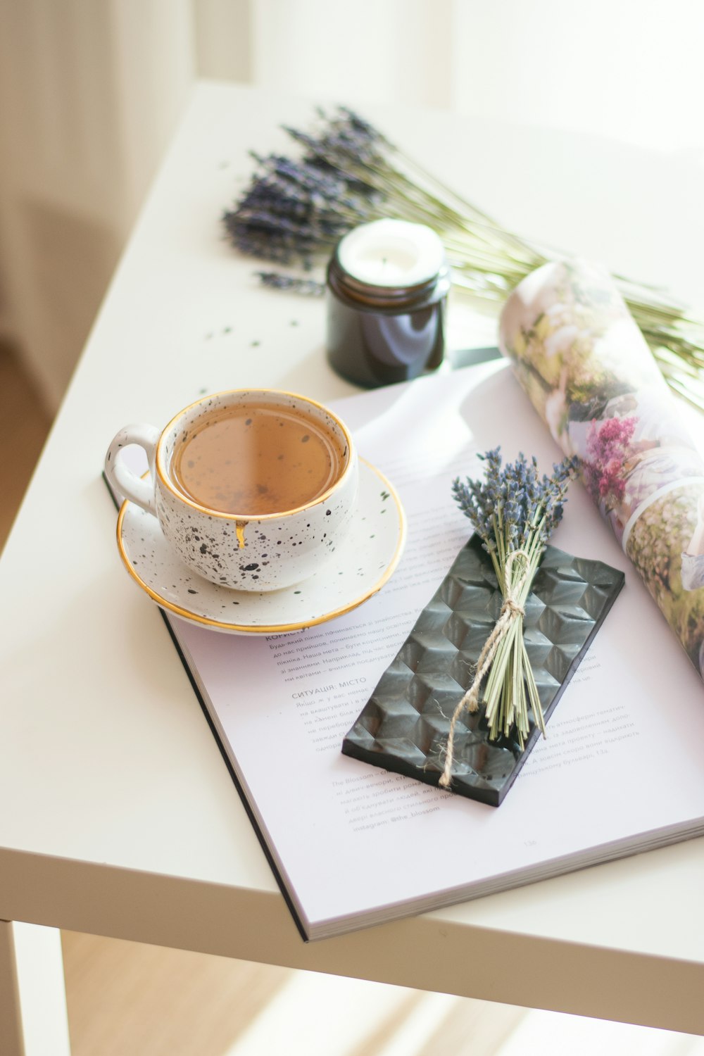 white ceramic cup beside flower