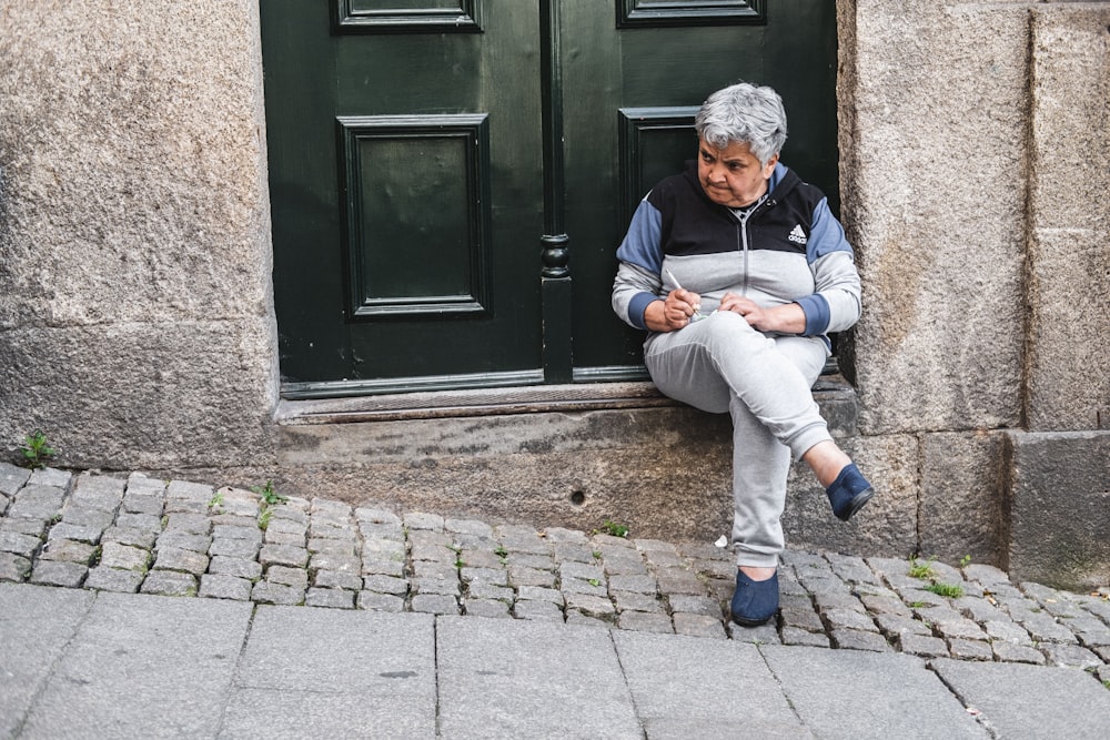 unknown person sitting near black wooden door