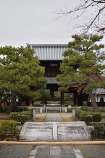 An ancient temple gate framed by colorful autumn leaves in a quiet mountain village.